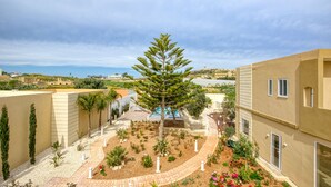 A courtyard with a central tree, surrounded by a garden with various plants and flowers. - Ta’ Benna Villa Gozo Luxury Accommodation (Ghajnsielem)