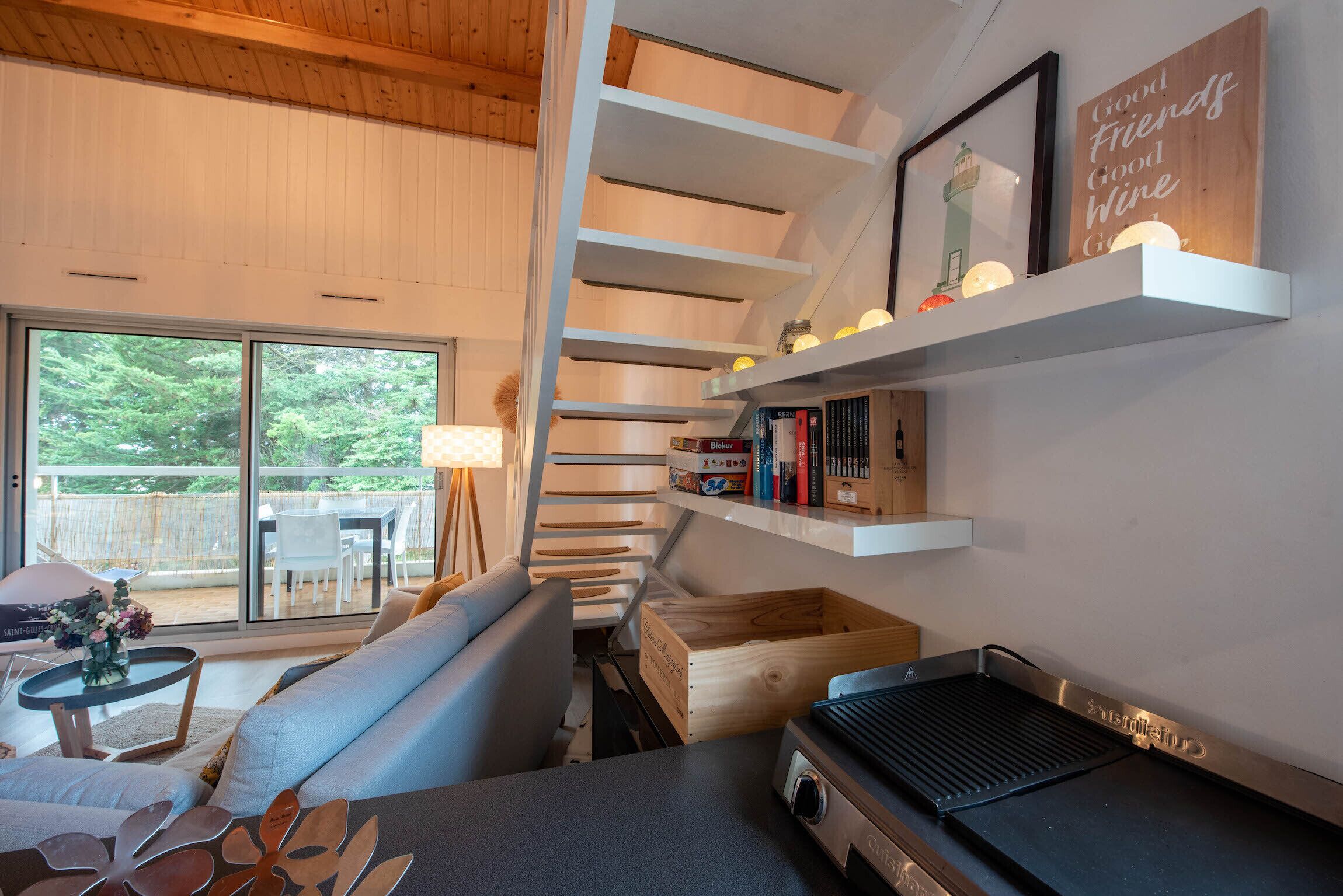 Een moderne woonkamer met een bank, een barbecue en een boekenkast.
