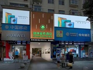 A building with multiple storefronts, including a Huawei store and a GreenTree store. - Greentree Inn Ankang Middle Bashan Road Business Hotel (Ankang)