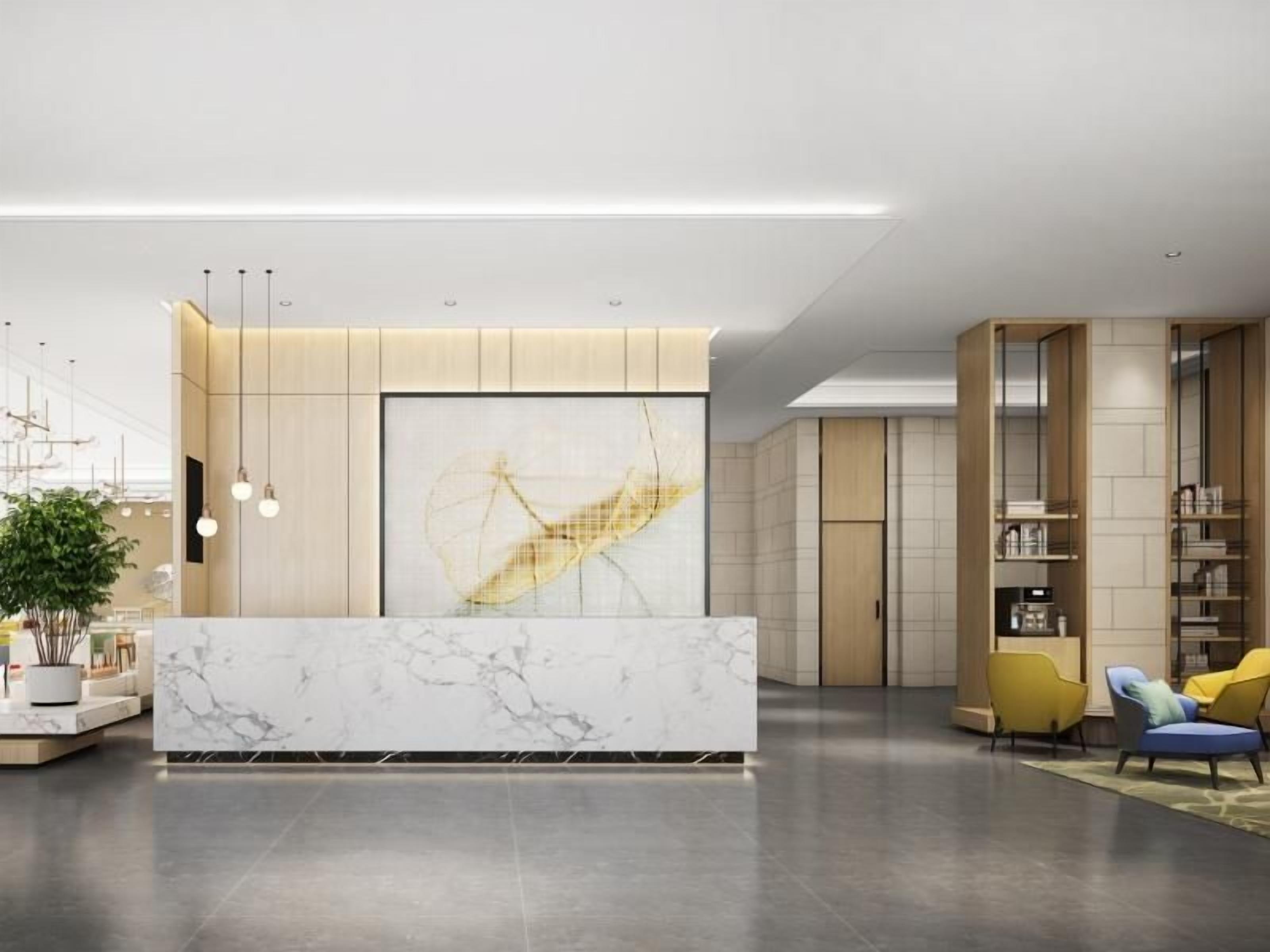 A modern reception area with a marble counter, a large abstract painting, and a seating area with yellow chairs.