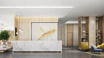 A modern reception area with a marble counter, a large abstract painting, and a seating area with yellow chairs.
