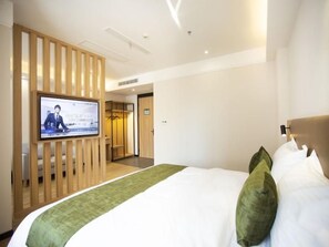 A hotel room with a bed, a television mounted on a wooden panel, and a door leading to a bathroom. - Greentree Inn Ankang Middle Bashan Road Business Hotel (Ankang)