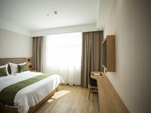 A modern hotel room with a large bed, a desk, and a TV mounted on the wall. - Greentree Inn Ankang Middle Bashan Road Business Hotel (Ankang)