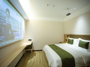 A hotel room with a bed, a desk, and a projector screen displaying a presentation. - Greentree Inn Ankang Middle Bashan Road Business Hotel (Ankang)