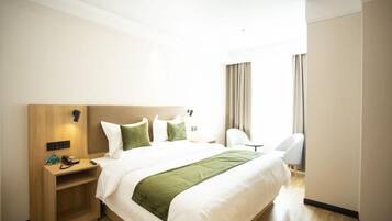 A hotel room with a bed, bedside table, chair, and curtains.