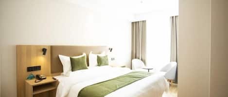 A hotel room with a bed, bedside table, chair, and curtains.