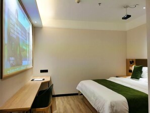 Una habitación de hotel con una cama, un escritorio y una pantalla para proyector.