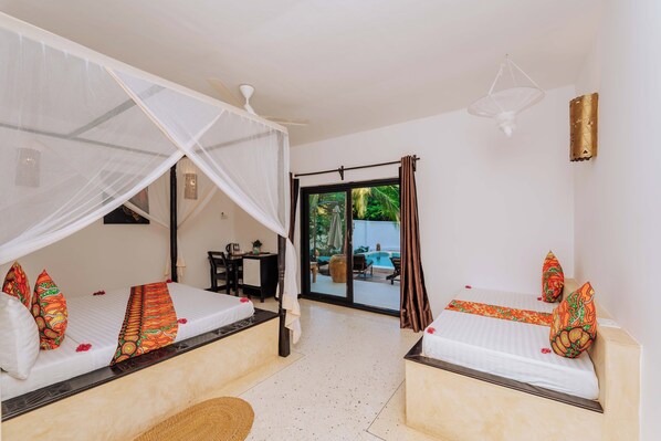 A room with two beds, a ceiling fan, a desk, and a view of an outdoor swimming pool. - 6-BEDROOMS POOL VILLA in JAMBIANI (Zanzibar east coast)