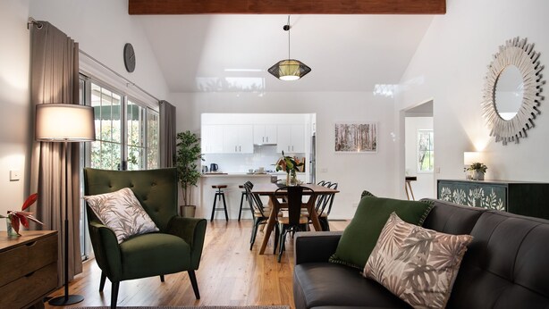 Una sala de estar moderna con un sofá, un sillón y una mesa de comedor.