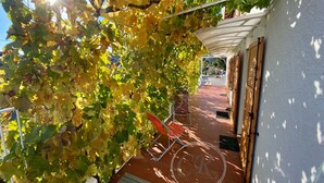 A covered outdoor area with a pergola, a bicycle, and a seating area. - LUXURY APARTMENT - T4 DUPLEX - 100 M FROM ST CLAIR BEACH (Le Lavandou)
