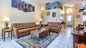 A spacious living room with two leather sofas, a coffee table, and a patterned rug. - Cloud 9 3/4 - Southern Pool, Privacy Fence! (Kissimmee)