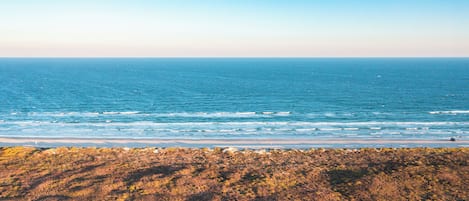 Paisagem costeira com vista para o oceano e um litoral rochoso.