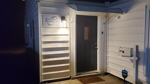 A white building with a sign reading "Railroad Ranch" and a door with a security system.