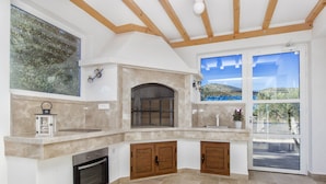 A kitchen with a stone backsplash, wooden cabinets, and a built-in oven. - Villa Antonia is near Trogir with a private pool (Marina)