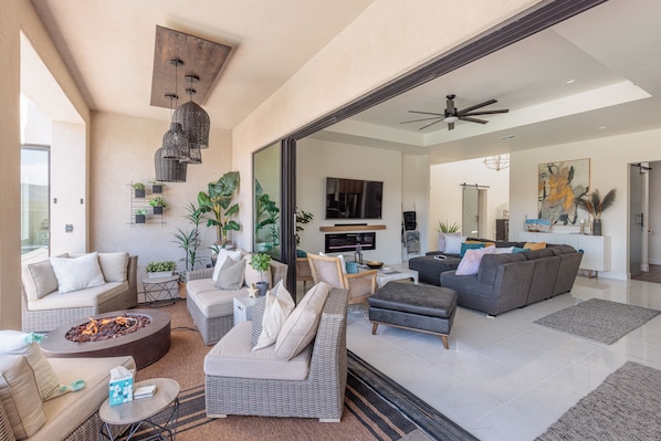 A spacious living room with a fireplace, sofas, and a television.