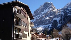 A multi-story building with balconies, a mountainous backdrop, and snow-covered surroundings. - 10m from resort center, 3rd floor, balcony, parking, tv, 20m², Pralognan-la-Vanoise (Pralognan-la-Vanoise)