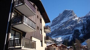 A multi-story building with balconies, set against a backdrop of snow-covered mountains. - 10m from resort center, 3rd floor, balcony, parking, tv, 20m², Pralognan-la-Vanoise (Pralognan-la-Vanoise)