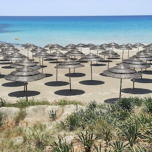 Playa en los alrededores, playa de arena blanca, camastros y sombrillas