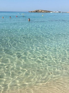 Playa en los alrededores, playa de arena blanca, camastros y sombrillas