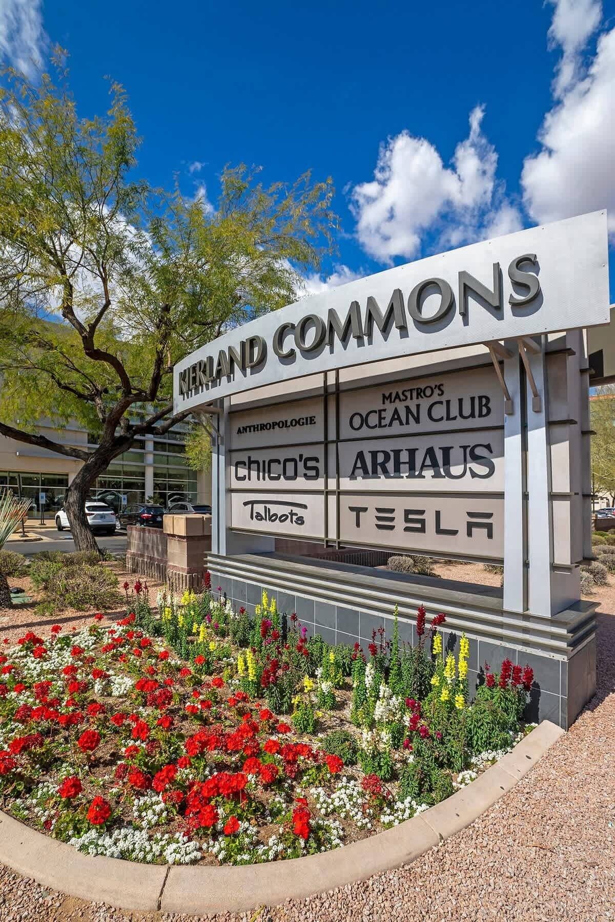A signboard for Grand Commons with various business names like 'Anthropologie', 'Ocean Club', 'Chico's', 'Arhaus', 'Talbots', and 'Tesla'.