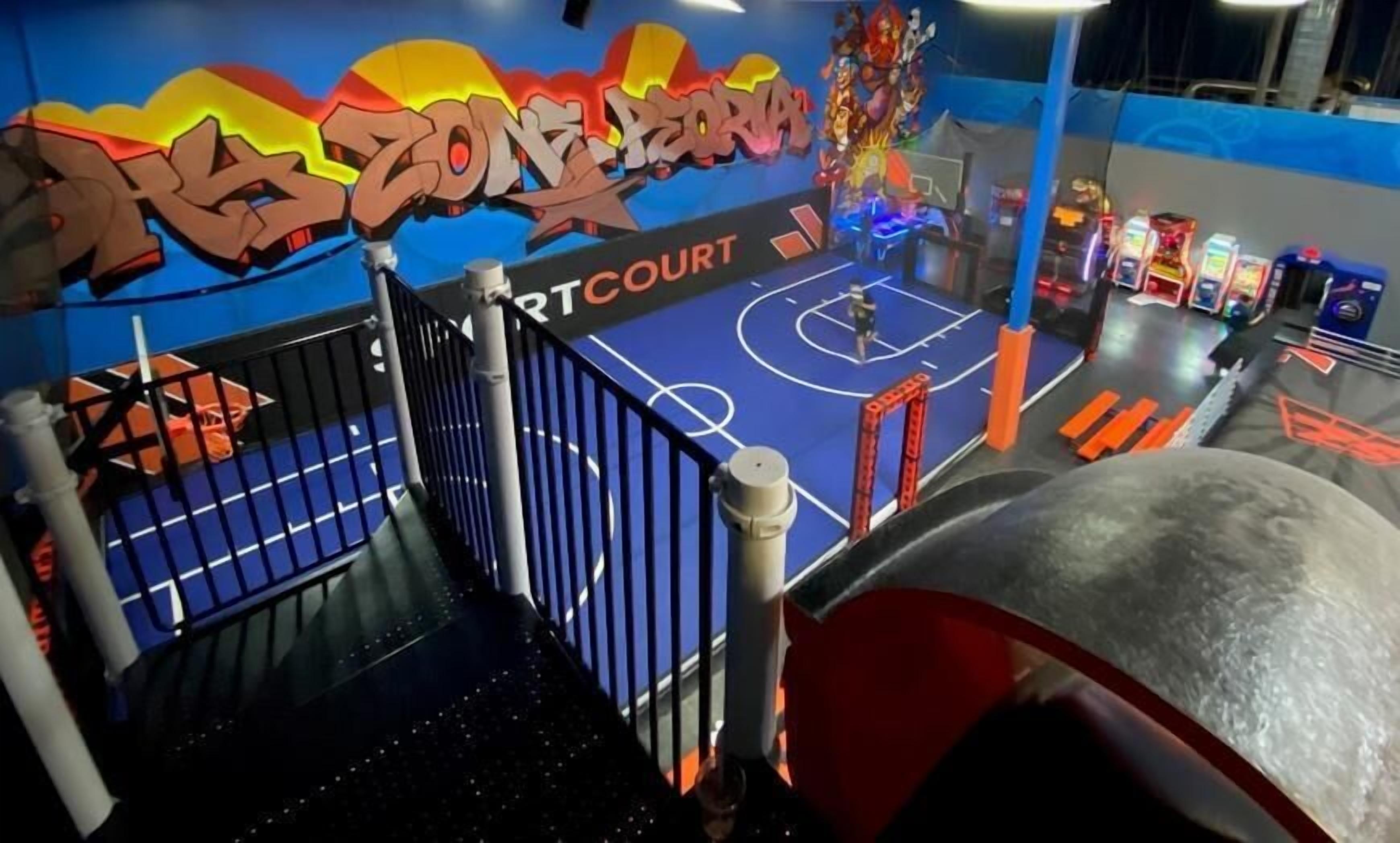 A basketball court with a colorful mural and a basketball hoop.