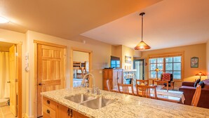 A kitchen with granite countertops, wooden cabinets, and a stainless steel sink. - Stunning mountain view, free wifi, underground parking (copper mountain)