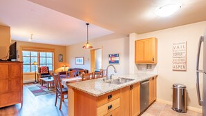 A modern kitchen with wooden cabinets, a granite countertop, and a stainless steel sink. - Stunning mountain view, free wifi, underground parking (copper mountain)