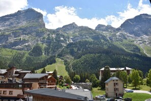 A mountain village with traditional wooden buildings, a ski resort, and a view of the surrounding mountains.
