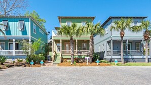 A row of historic houses with front porches, palm trees, and a clear blue sky. - Steps from Pool, Mins to Beach in Blue Mountain + Free Attraction Tickets! (Santa Rosa Beach)