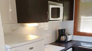 A compact kitchen with a white refrigerator, a microwave, a coffee maker, and a dishwasher. - Ski-in/ski-out & foot of the slopes, swimming pool, sauna, hammam, terrace, tv, ski locker, 43m² (Les Orres)