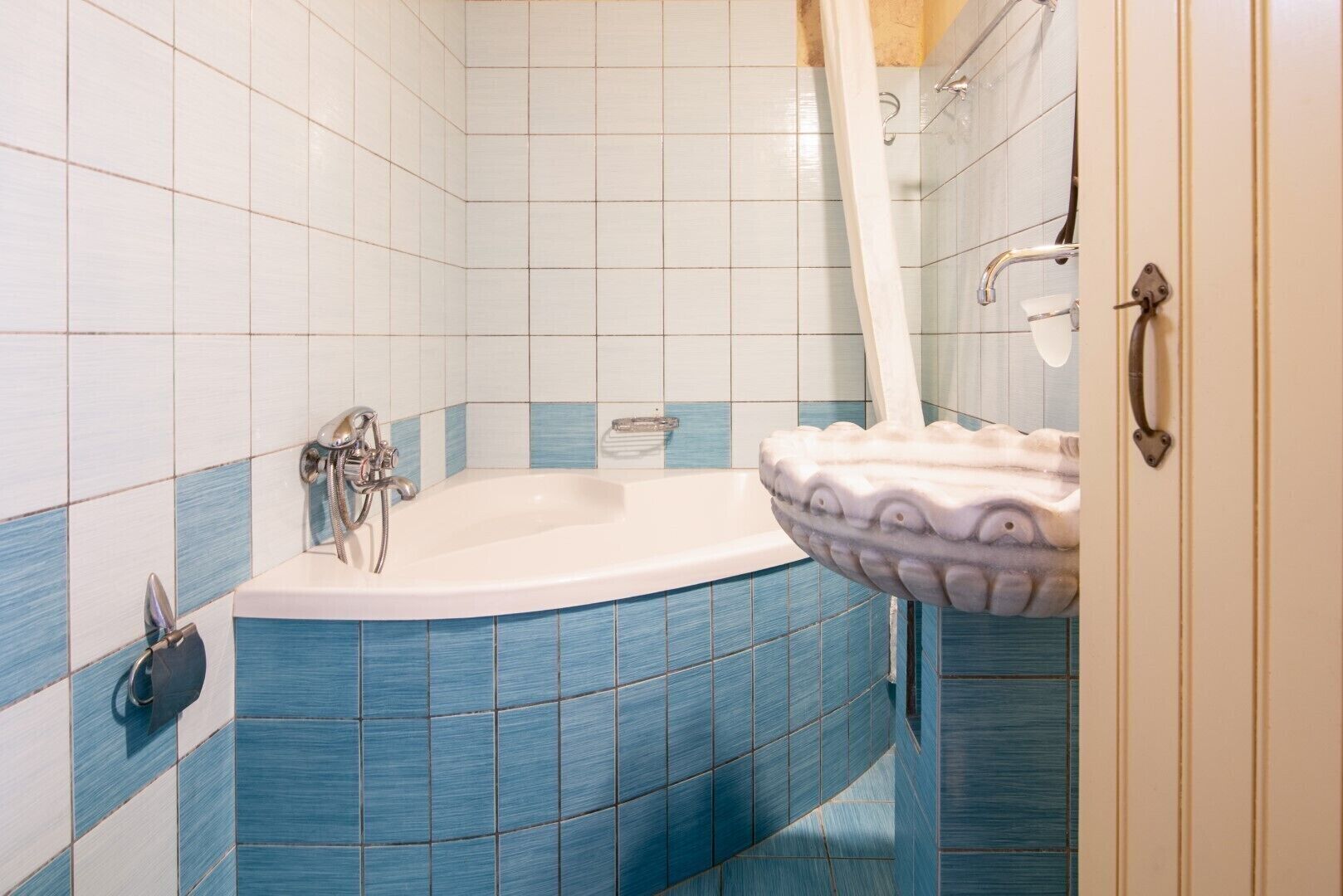 Un baño con bañera independiente, lavamanos con lavabo decorativo e inodoro.