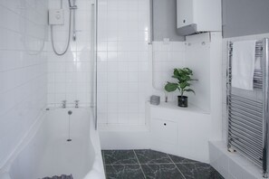 Departamento clásico | Baño | Tina con regadera y toallas 