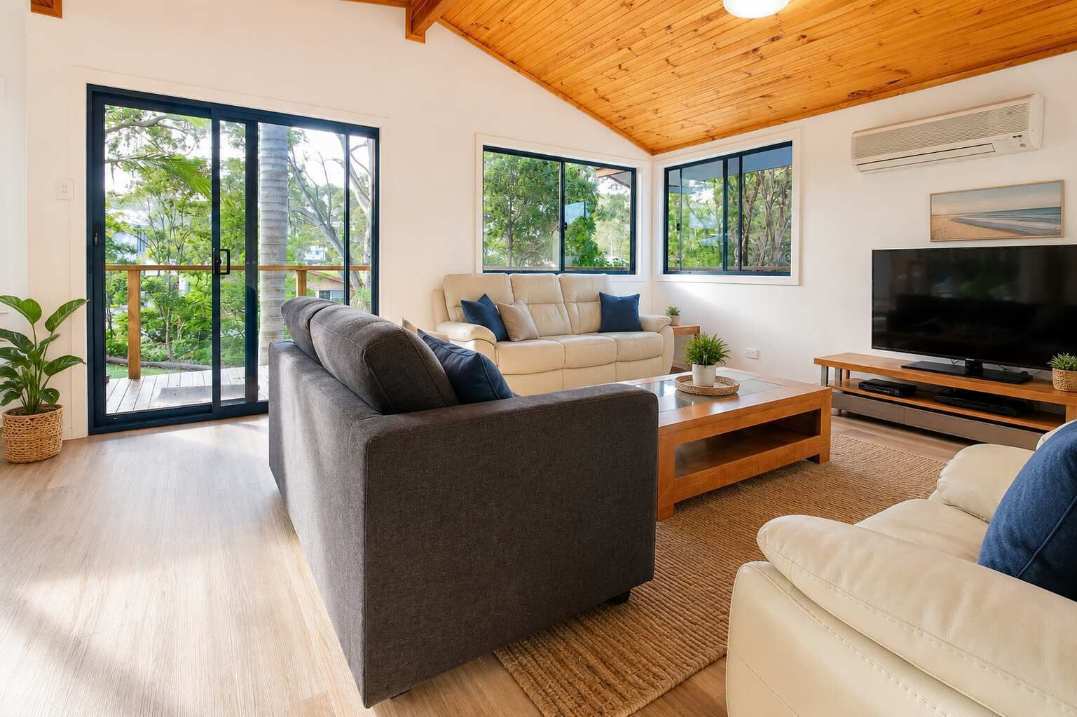 A modern living room with a sofa, a coffee table, and a TV.