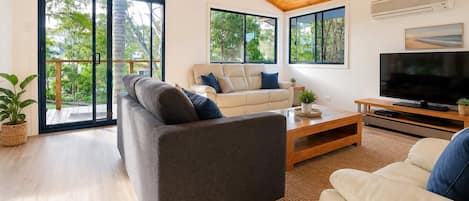 A modern living room with a sofa, a coffee table, and a TV.