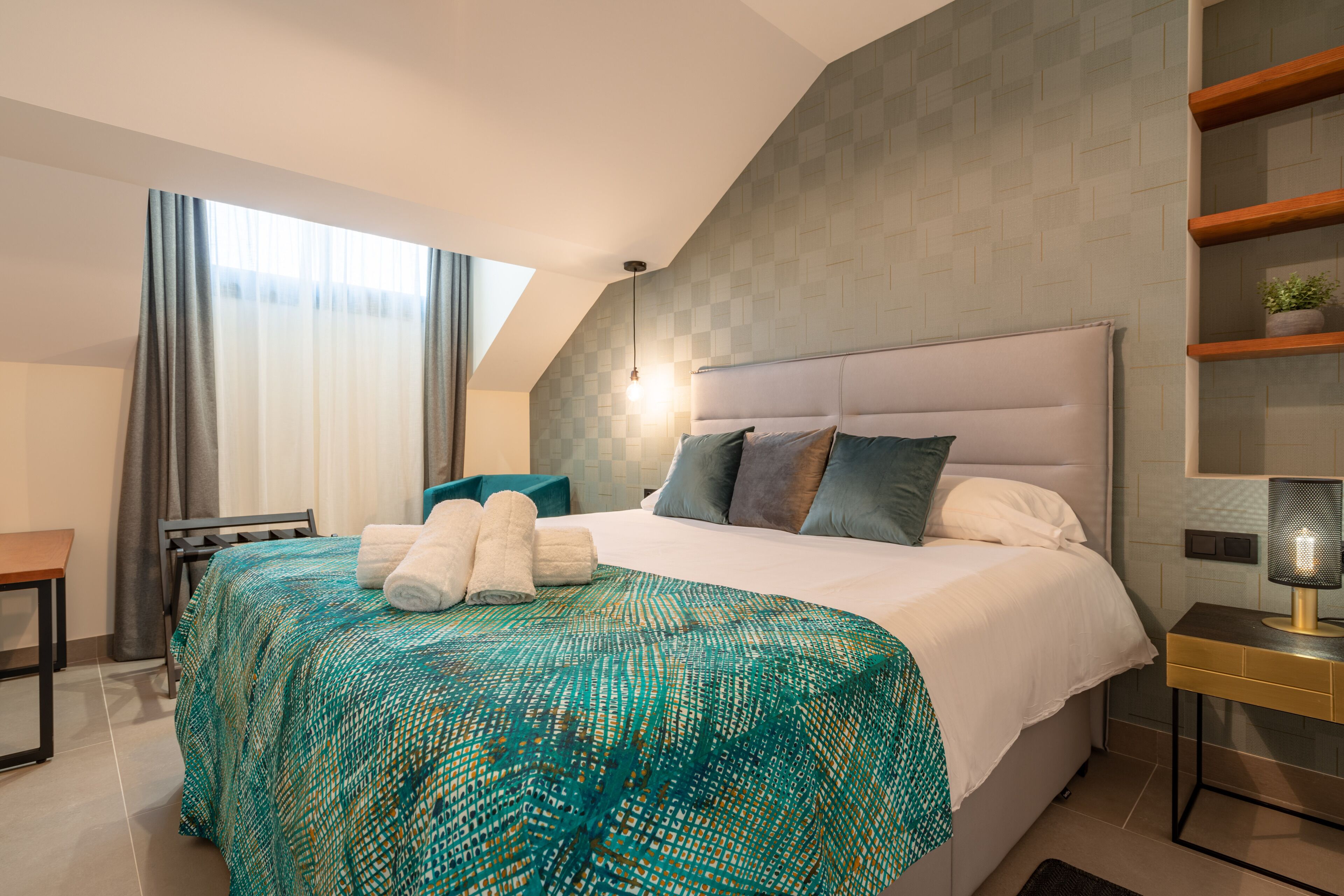 Una habitación de hotel moderna con una cama grande, un escritorio y una silla.