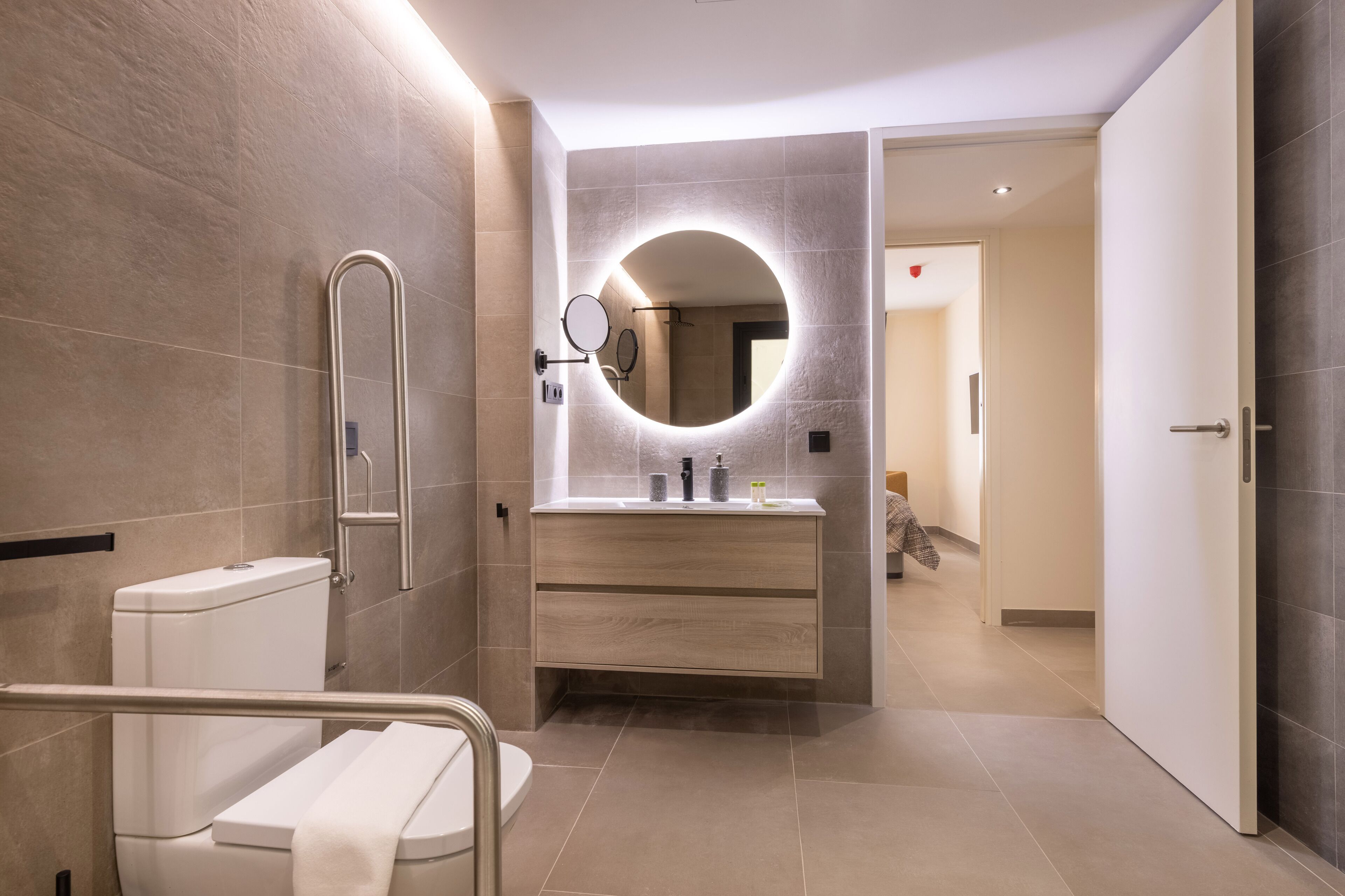 A modern bathroom with a toilet, a sink with a mirror, and a shower area.