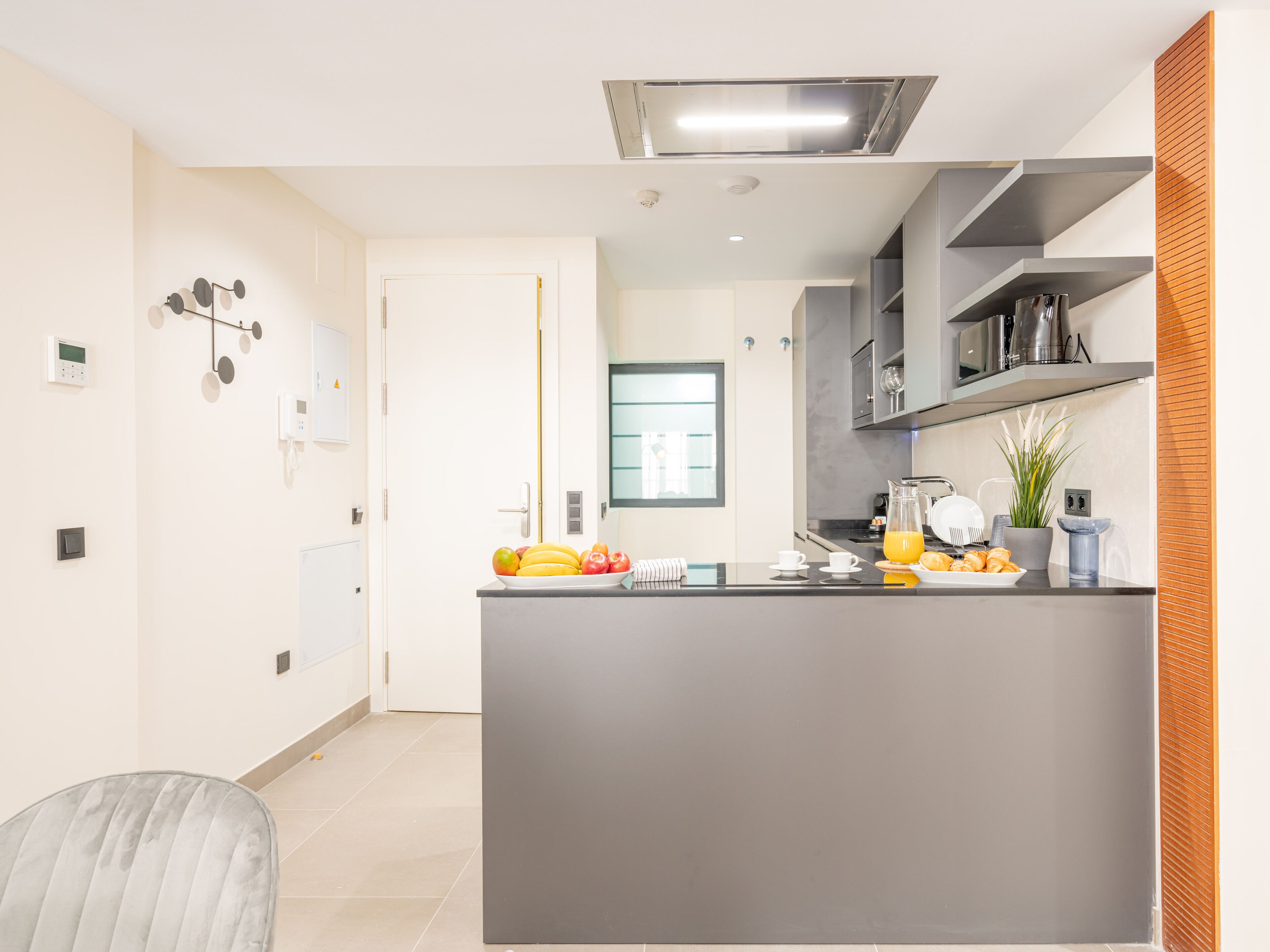 Una cucina moderna con isola centrale, elettrodomestici integrati e vista sull'area pranzo.