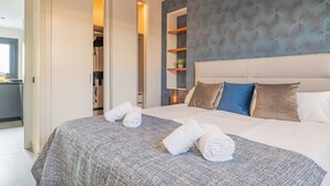 Ett modernt hotellrum med en stor säng, en rymlig klädkammare och en vägg med ett mönster.