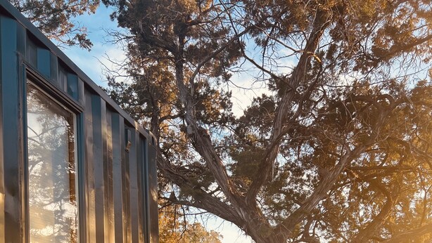 A wooden deck with two black wire chairs and a decorative planter. - The Indigo House at Canyon Lake (Canyon Lake)