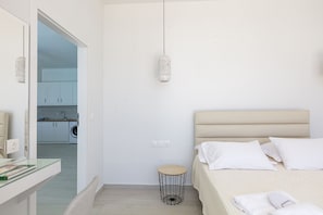 A bedroom with a bed, bedside table, and a hanging light fixture. - Petres villa 4,Private pool,Near tavern & Plakias (Mariou)
