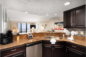 Enjoy a meal with a view from this kitchen, which features a dishwasher and large sink.
