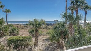 A view of a beach with palm trees and a clear sky. - Enjoy the Large Wrap Around Ocean Front Balcony! (Hilton Head Island)