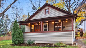 Ein eingeschossiges Haus mit Satteldach, einer Veranda mit Lichterkette und einer Satellitenschüssel.