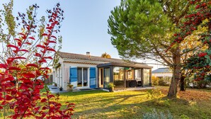 A modern house with a glass door entrance, a visible patio area, and a well-maintained lawn. - Gawa's House - Maison avec jardin proche mer (Meschers-sur-Gironde)