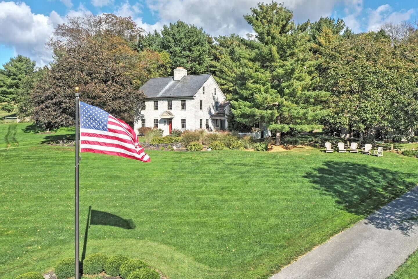 A large stone building with a well-maintained lawn and a flagpole with an American flag.