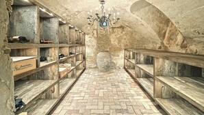 Une cave avec des étagères en bois et un lustre.