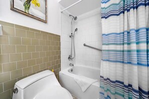 A bathroom with a bathtub, a toilet, and a shower.
