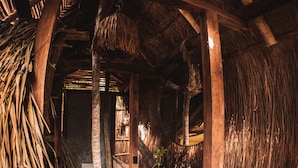 A rustic wooden staircase with a thatched roof, leading to a room with a wooden railing and a hanging plant. - Uman Glamping & Cenote Tulum (Tulum)