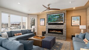 A modern living room with a fireplace, large TV, and comfortable seating.