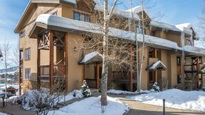 A multi-story wooden building with balconies and snow-covered roofs.